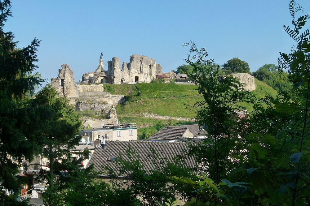 De kasteelruïne van Valkenburg op de heuvel boven de stad onder een blauwe lucht